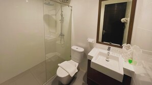 A modern bathroom with a glass-enclosed shower, a toilet, and a sink with a mirror above it. - UMASAN COLIVING & RESTO PONDOK INDAH (Jakarta)