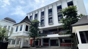 A multi-story building with a flat roof and a sign reading "UMASAN". - UMASAN COLIVING & RESTO PONDOK INDAH (Jakarta)