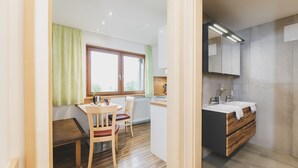 A modern kitchen with a wooden countertop, a built-in oven, and a large window. - Apartment 16 – Haus Voglreiter with Mountain View, Shared Garden and Wi-Fi (Kaprun)