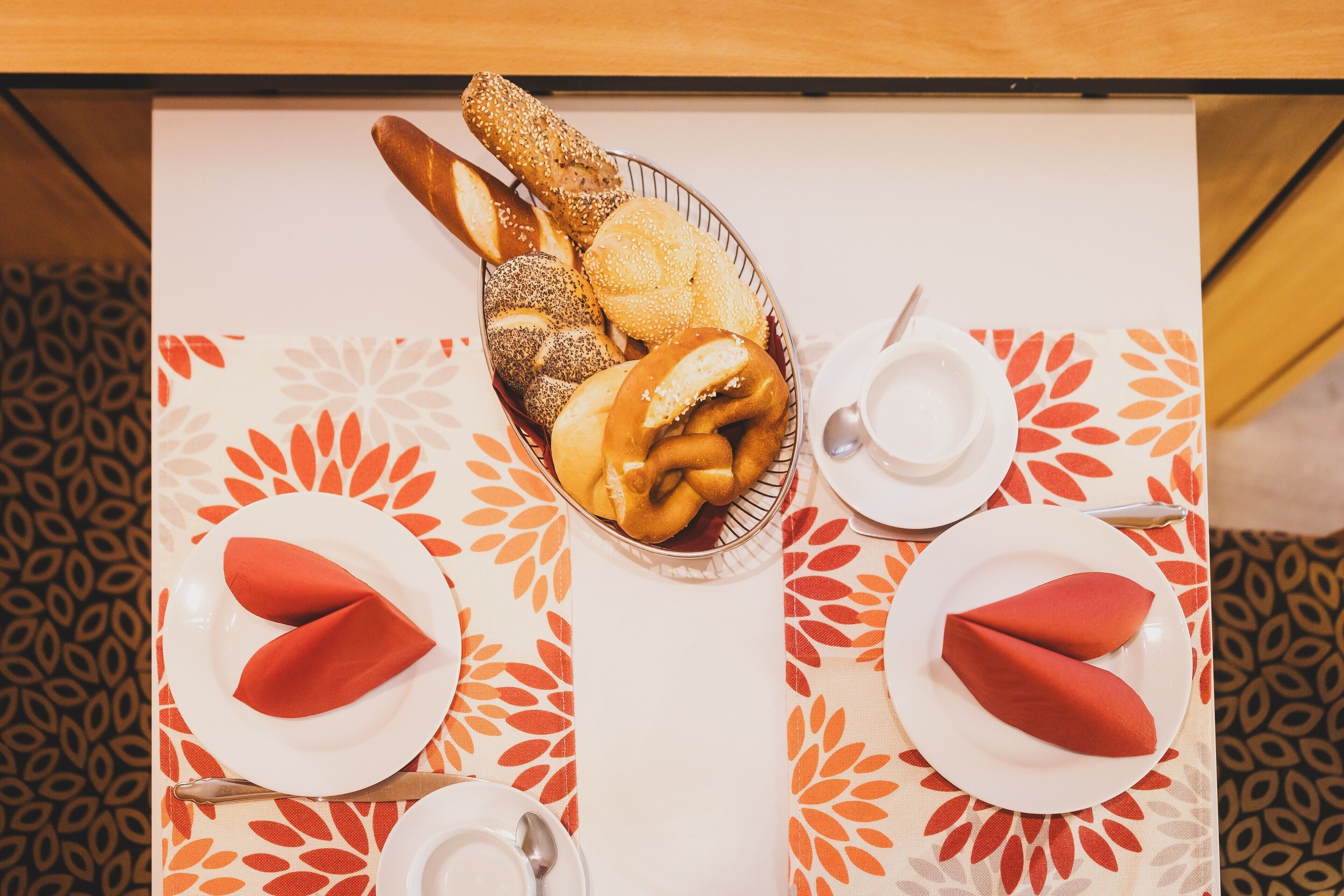 A table set with bread, rolls, and napkins.