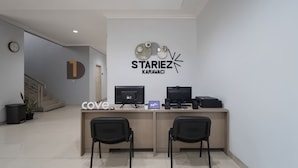 Una reception con due monitor, un portatile e un altoparlante. All' parete, un orologio e un cartello con la scritta "STARIEZ KARAVACI".