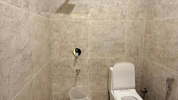 Un baño con inodoro, bidé y ducha.