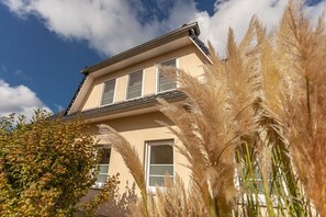 Un edificio a due piani con facciata beige, ampie finestre e tetto piano.