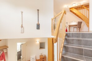 Un escalier avec des rampes en bois menant à un deuxième étage.