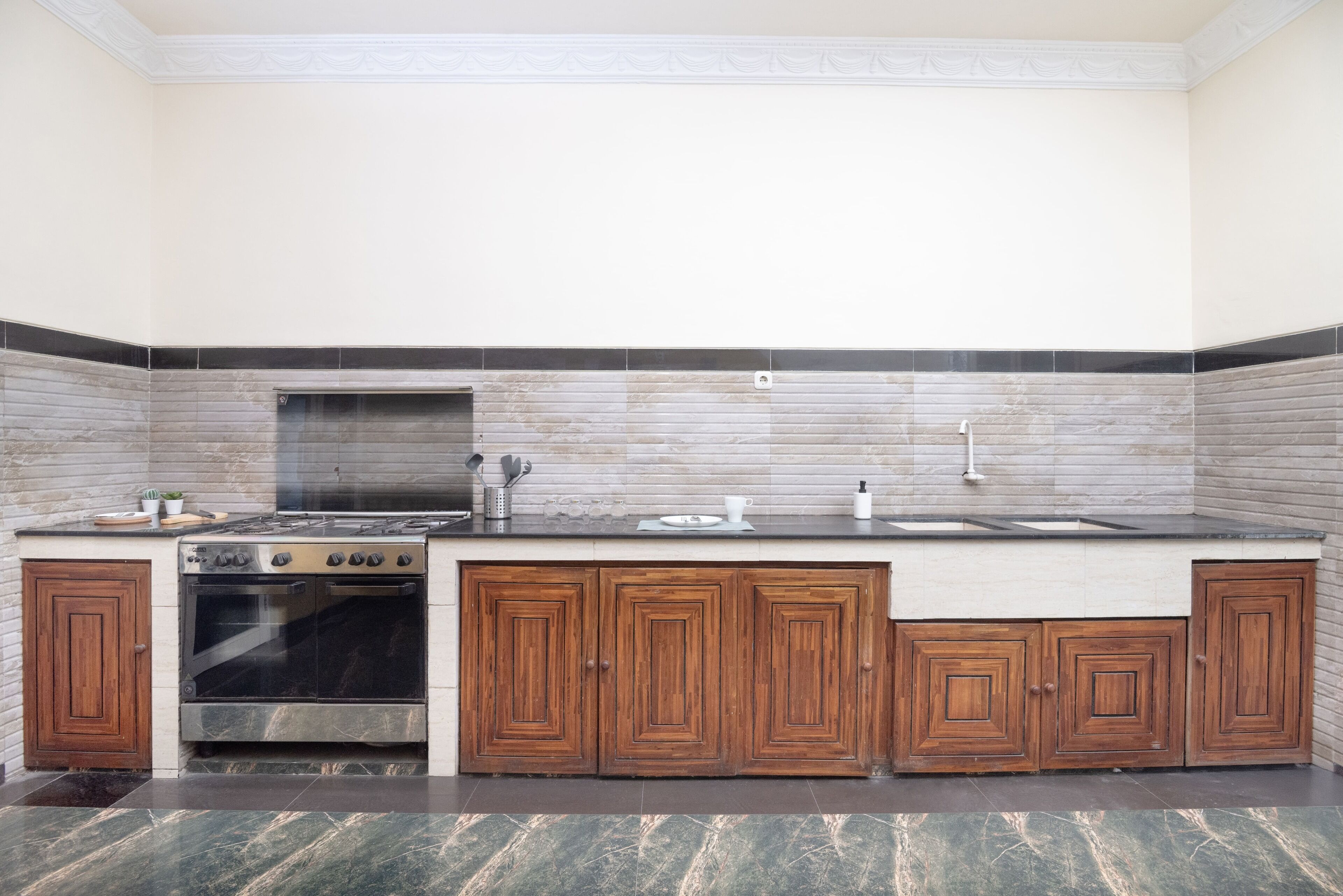 Una cocina con estufa, horno, lavaplatos y armarios de madera.