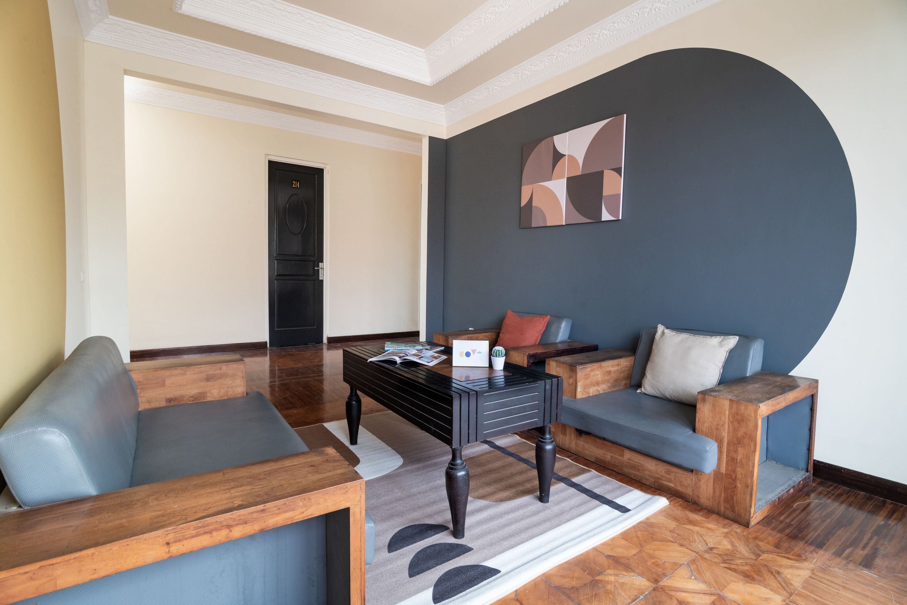 A modern living room with a sofa, a coffee table, and a blue accent wall.