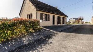 A single-story house with a sloped roof, a front door, and a small porch. - Pavilion in the Loir Valley (Saint-Rimay)