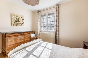 2 dormitorios y tabla de planchar con plancha