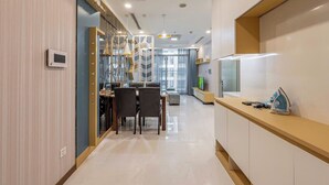 Une cuisine moderne avec un coin repas, comprenant un four encastré, une machine à café et un téléviseur.