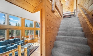 A wooden interior with a staircase leading to an upper level. - The Kool Kabin | Chill Deck, Fire Pit & BBQ Grill (Duck Creek Village)