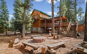 A cabin with a deck, a fire pit, and a staircase leading to an upper level. - The Kool Kabin | Chill Deck, Fire Pit & BBQ Grill (Duck Creek Village)