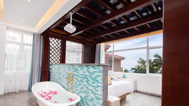 A bathroom with a freestanding bathtub, a tiled shower area, and a window with a view of palm trees. - Sanya Anyun  Coastal Lodge (Sanya)