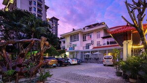A hotel with a paved courtyard, parked cars, and a building with balconies. - Sanya Anyun  Coastal Lodge (Sanya)