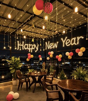 A New Year's celebration with a 'Happy New Year' sign, balloons, and a city view.