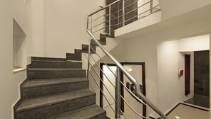 Una escalera moderna con barandilla metálica que conduce a un segundo piso.