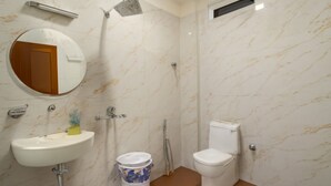 Un baño con lavamanos, inodoro, ducha y espejo.
