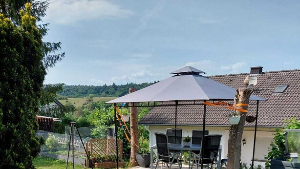 Un patio trasero con un estanque, un pabellón y una zona de comedor.