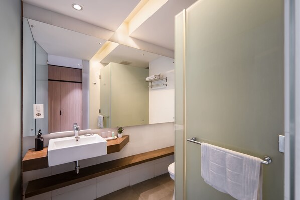 A modern bathroom with a large mirror, a white sink, and a towel rack. - Cove Southouse Residence (Jakarta)