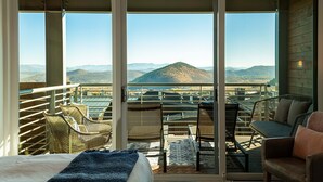 A balcony with wicker chairs, a small table, and a bed with a blue blanket. - All-Season Escape | Ski-In/Out + Hot Tub + Clubhouse Amenities Canyons Village (Park City)