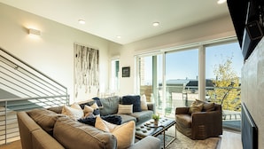 A modern living room with a sofa set, a coffee table, and a chair. There is a staircase with a railing leading to an upper level. - All-Season Escape | Ski-In/Out + Hot Tub + Clubhouse Amenities Canyons Village (Park City)