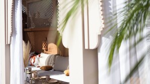 An outdoor seating area with a table, chairs, and a hanging light fixture. - Riad le terra cotta (Marrakech)