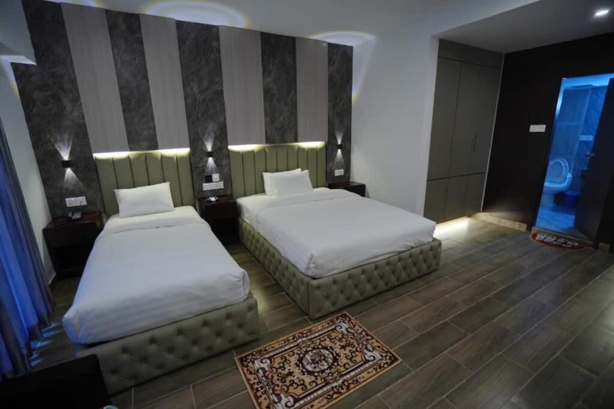 Une chambre d’hôtel avec deux lits, un tapis à motifs et un design moderne.