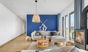 A modern living room with a blue accent wall, a wooden coffee table, a sofa, and a fireplace.
