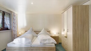 Una camera da letto con un letto di legno, comodini, un armadio e una finestra con tende.