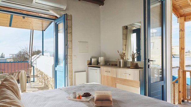 Une chambre à coucher avec un lit, une table de chevet sur laquelle se trouve un plateau de nourriture, un miroir et une vue sur l’extérieur.