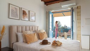 Une chambre avec un grand lit, une fenêtre et un balcon.