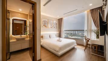 A modern hotel room with a large bed, a desk, and a city view.