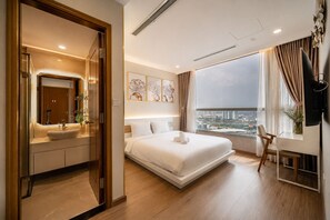 A modern hotel room with a large bed, a desk, and a city view. - Vinhomes Skyline Apartment Saigon (Ho Chi Minh City)