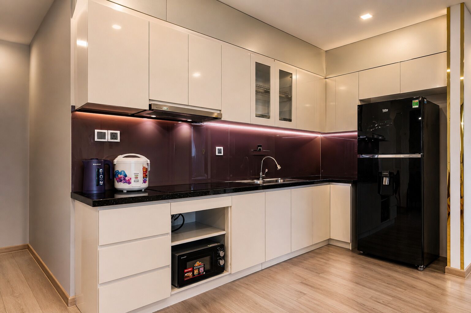 A modern kitchen with white cabinetry, a black refrigerator, and a microwave.