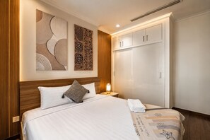 A hotel room with a bed, a nightstand, a wardrobe, and decorative wall art. - Vinhomes Skyline Apartment Saigon (Ho Chi Minh City)