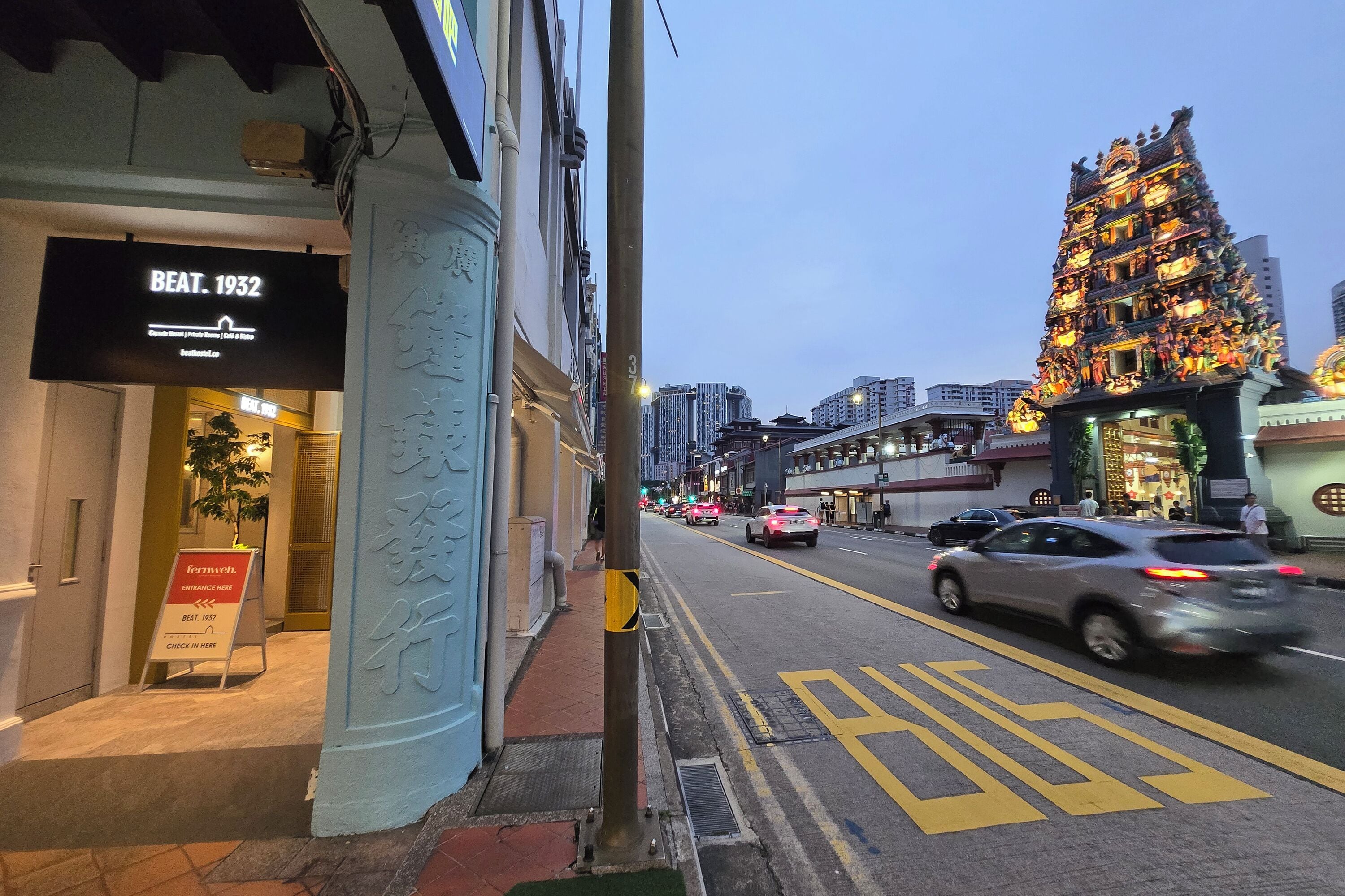 A street view with a building featuring a sign for 'BEAT 1932'.
