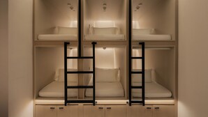 Habitación con literas, estanterías empotradas y espacios de almacenamiento.
