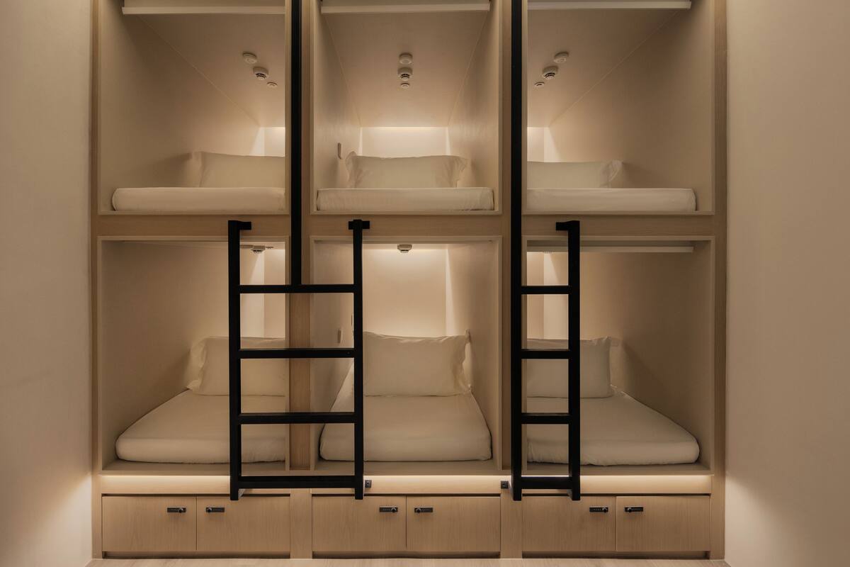 Habitación con literas, estanterías empotradas y espacios de almacenamiento.