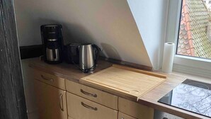 A kitchen with a stove, oven, and coffee maker on the counter. - Stay in a Historic Half-Timbered House (Nürnberg)