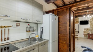Una cocina con refrigerador integrado, pileta y alacenas de madera.
