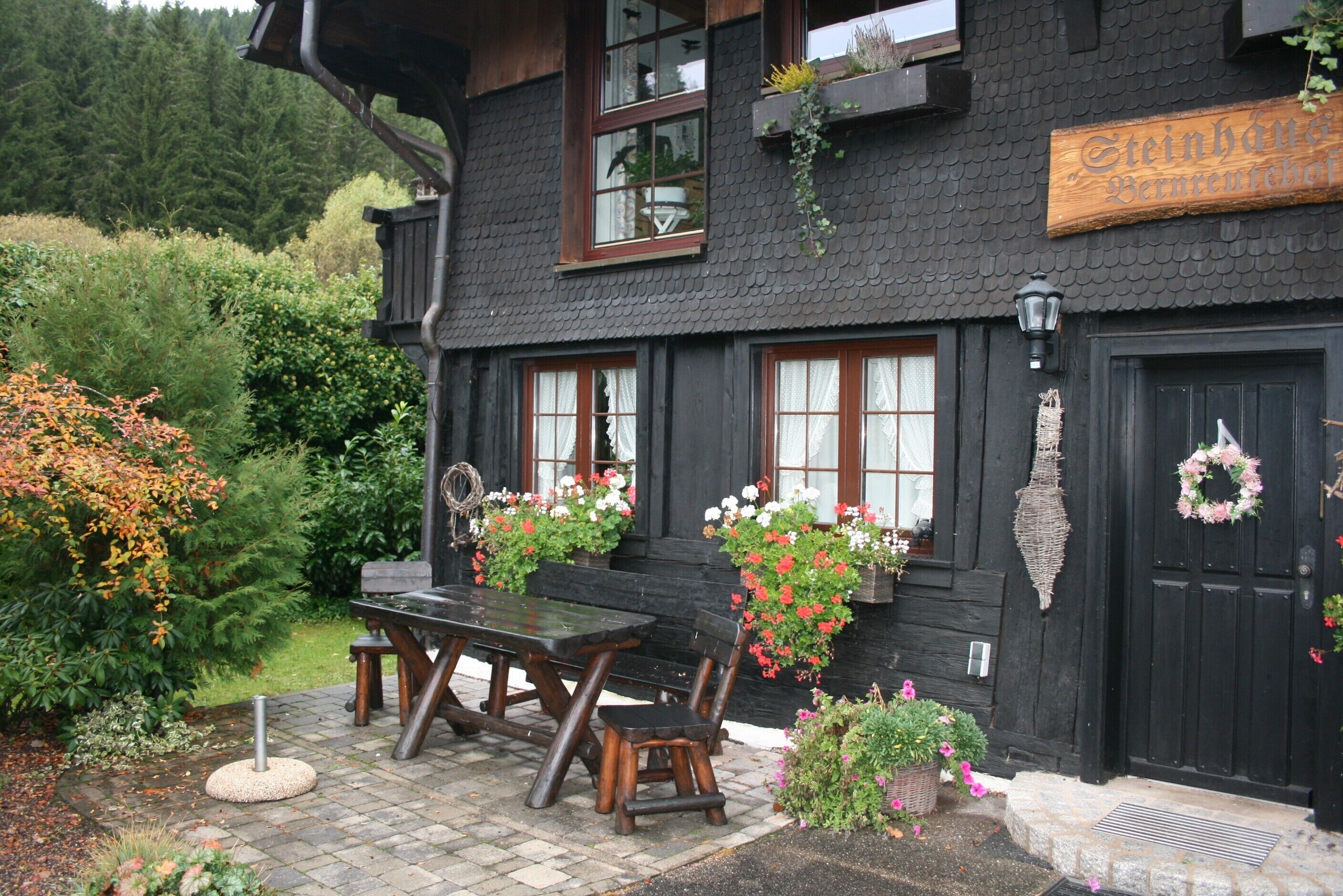 En svart träbyggnad med en skylt som visar texten ”Steinhause Bernerhof”.