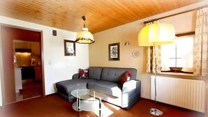 Un salon avec un canapé, une table basse, une lampe et un radiateur.