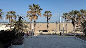 A beach view with palm trees and a clear sky.