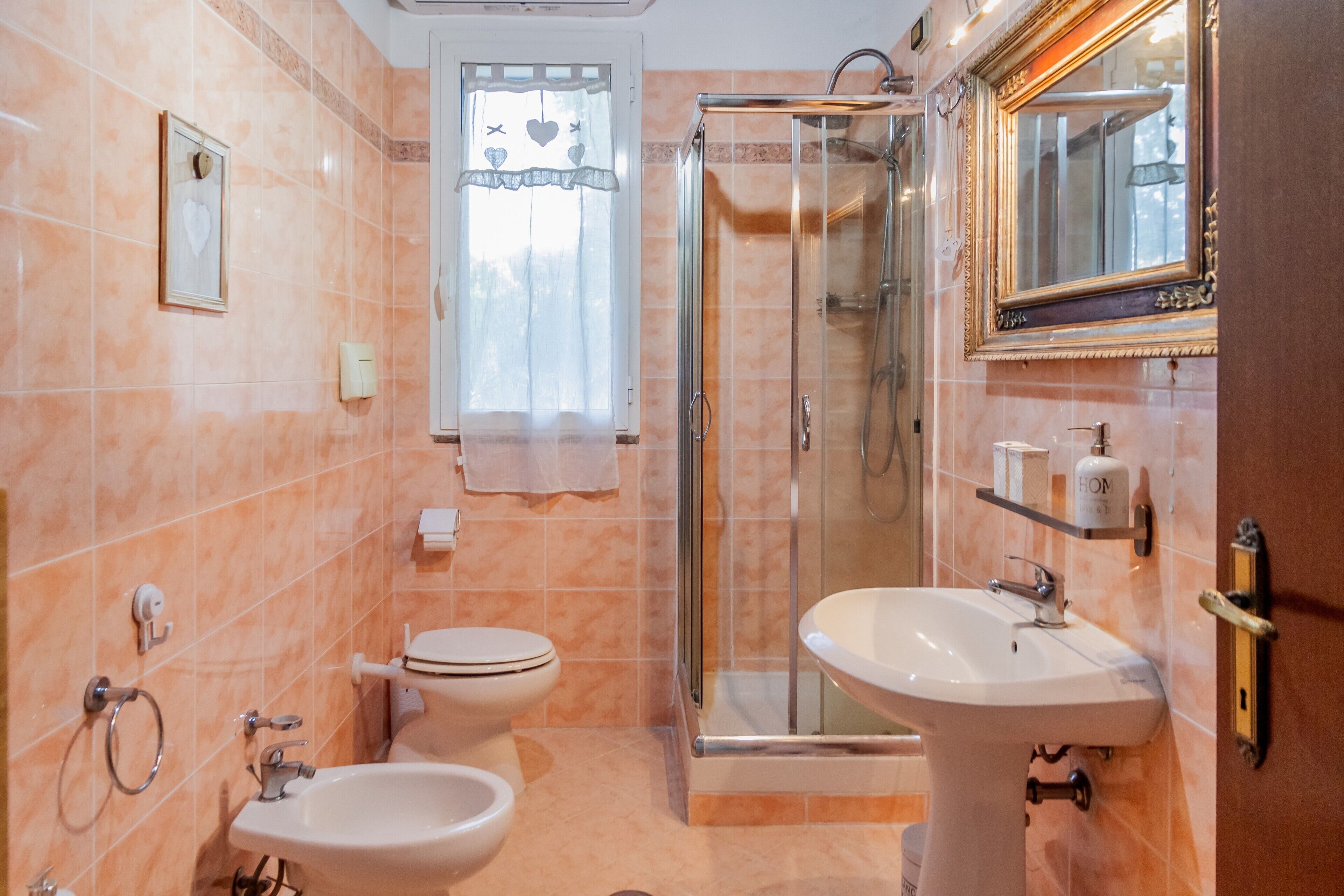 Une salle de bain avec une douche à parois de verre, un lavabo, des toilettes et un miroir.