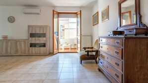 A spacious room with a wooden cabinet, a large mirror, and a chair.