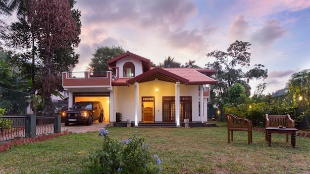 A two-story house with a garage, a front porch, and a well-maintained lawn. - Kings Court Residency  (Ampiyiya)