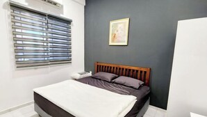 Ein Schlafzimmer mit einem Bett, einem Fenster mit Jalousien, einem gerahmten Bild an der Wand und einem weißen Kleiderschrank.