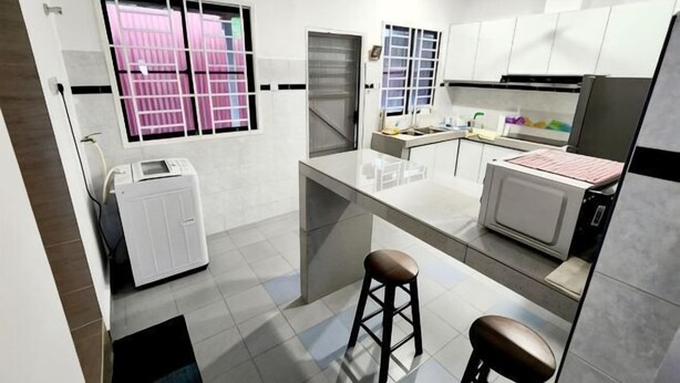 Eine moderne Küche mit Einbauofen, Mikrowelle und Kühlschrank. Es gibt ein Fenster mit Jalousien, einen Deckenventilator und einen Barhocker.