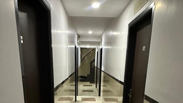 A corridor with a glass railing, a staircase, and a tiled floor. - Hotel Ajwa (Mumbai)