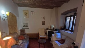 Una sala de estar acogedora con sofá, sillones, una mesita y televisor.