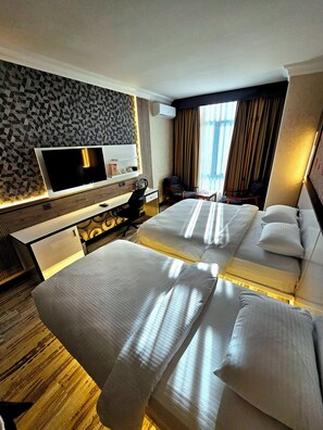 Habitación familiar con 2 camas individuales, balcón, vista a la ciudad | Camas Select Comfort, minibar y escritorio 